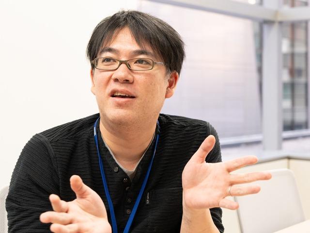 Man wearing glasses and a black long-sleeved shirt.