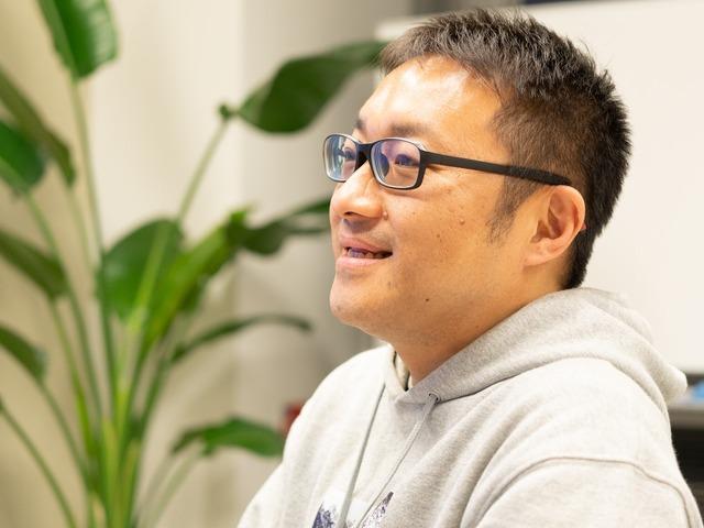 Man wearing glasses and a gray hoodie.