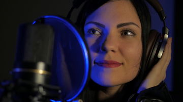 Woman with headphones in recording studio.