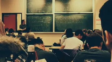 Students sitting on chairs in front of chalkboard - Bridging the accommodations gap in K12 and higher education