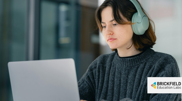A woman with headphones in front of a computer.