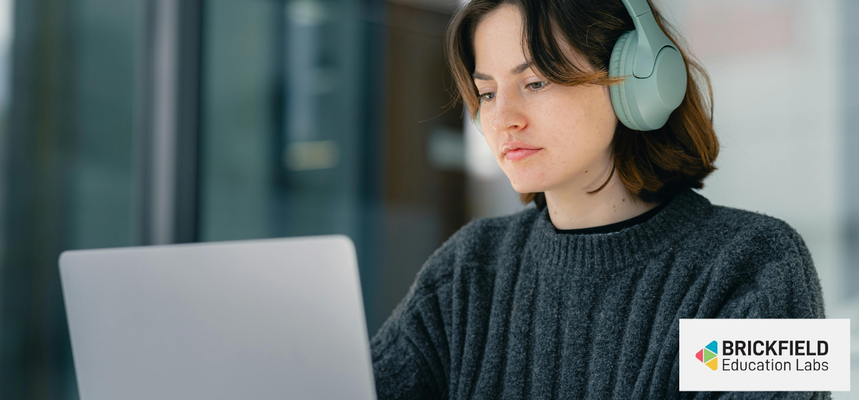 A woman with headphones in front of a computer.