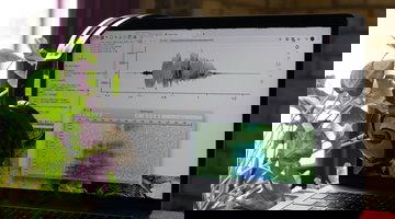 An open laptop showing soundwaves, representing spoken audio.