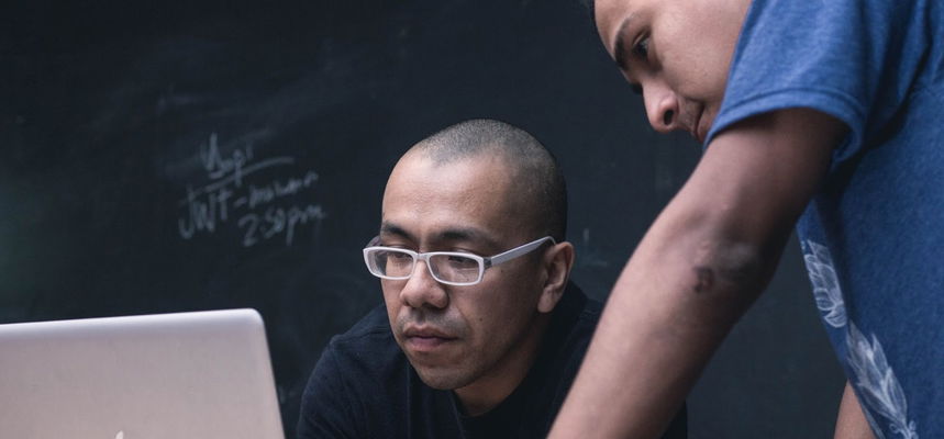 Two higher education students in front of a computer