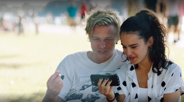 Jongen en meisje die samen naar een video kijken op een smartphone.