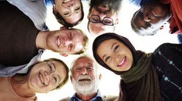 Concept of ReadSpeaker multilingual Neural TTS expressed via image of people of different cultures in a circle looking down ,